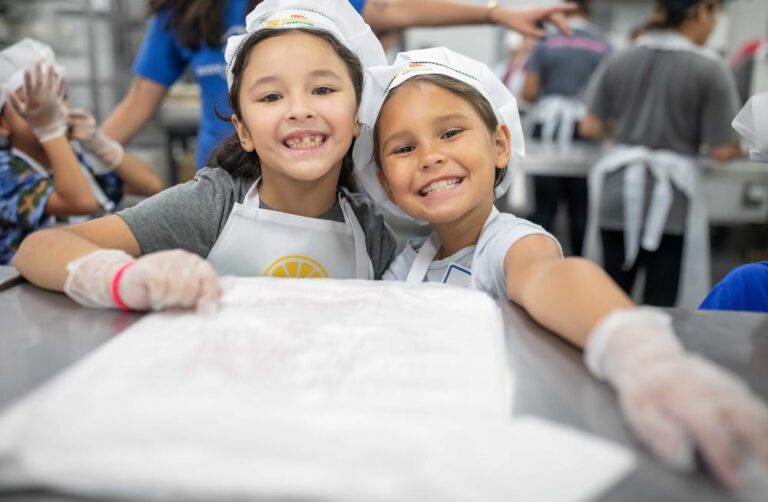 Two girls volunteer at the San Antonio Food Bank.