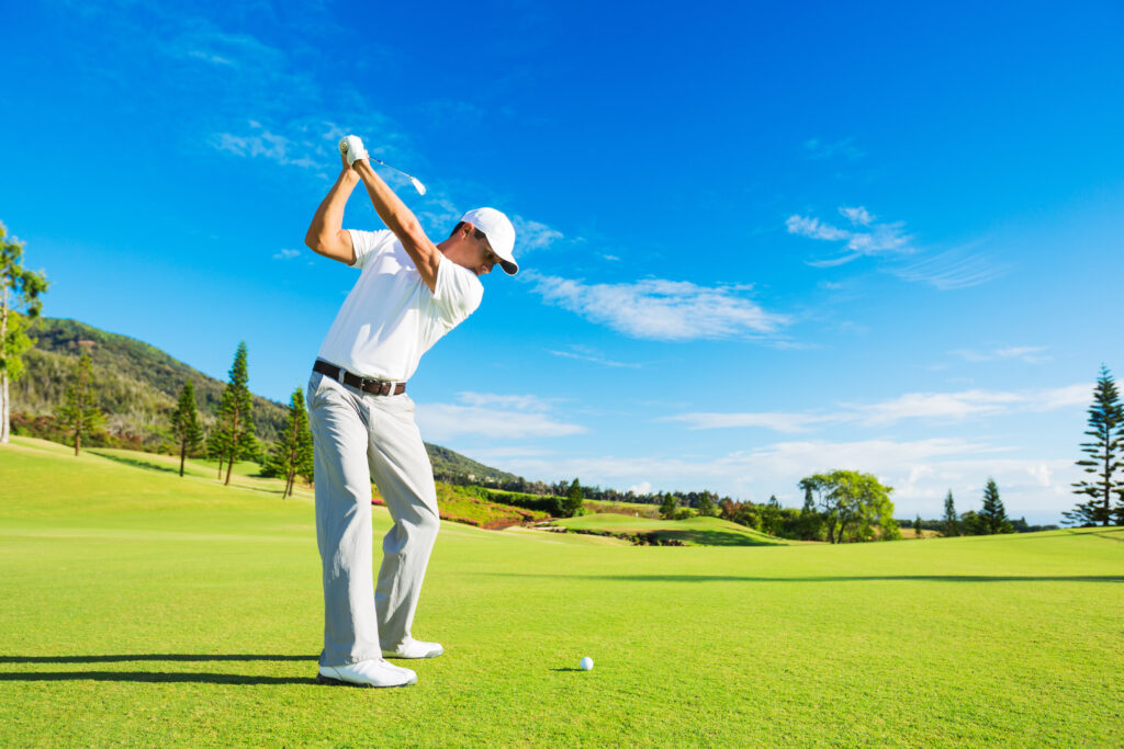 Golfer Hitting Golf Shot with Club on the Course