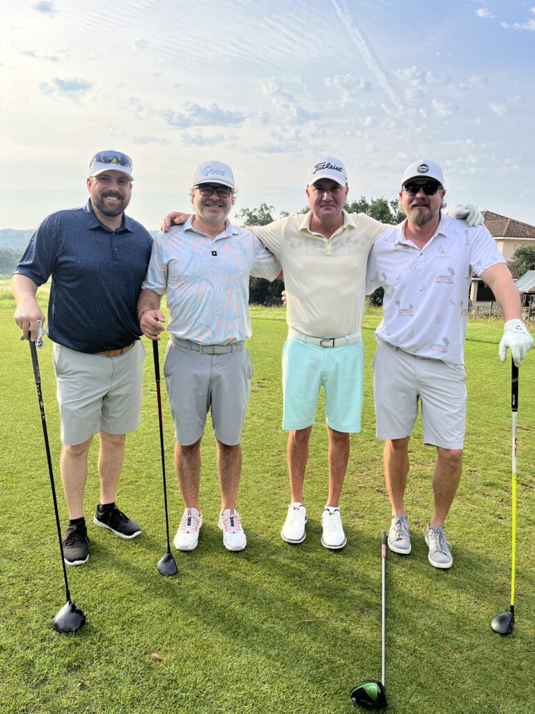 Golfers take a team photo on the green at the Driving fore Donors Golf Tournament