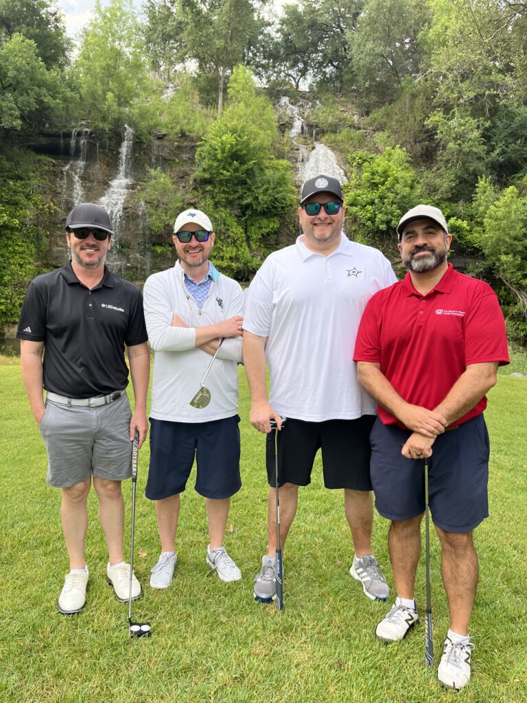 Golfers take a team photo on the green at the Driving fore Donors Golf Tournament