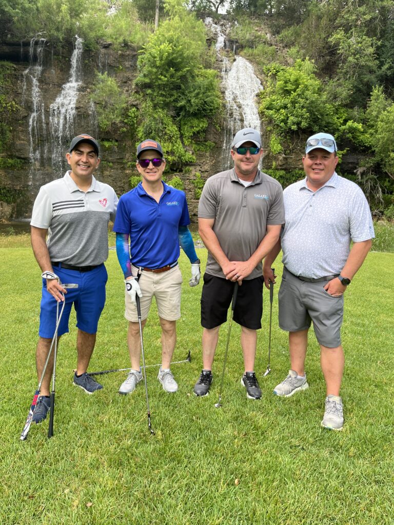 Golfers take a team photo on the green at the Driving fore Donors Golf Tournament