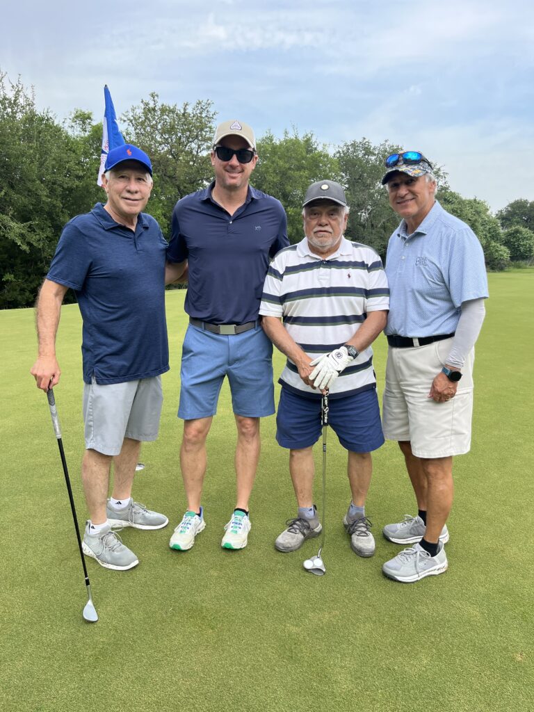 Golfers take a team photo on the green at the Driving fore Donors Golf Tournament