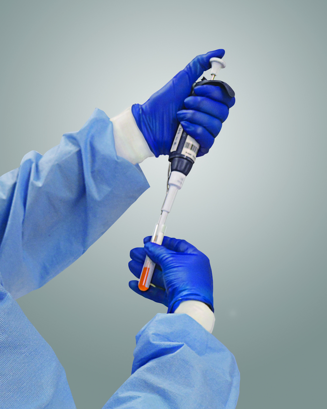 Gloved hands holding a cellular therapy instrument