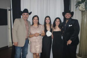 Five people dressed formally posing indoors