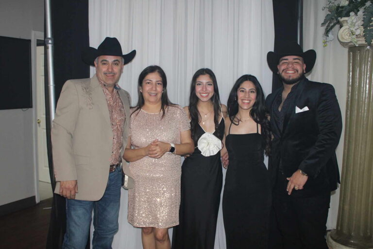 Five people dressed formally posing indoors