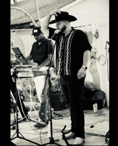Singer in cowboy hat performing with keyboardist