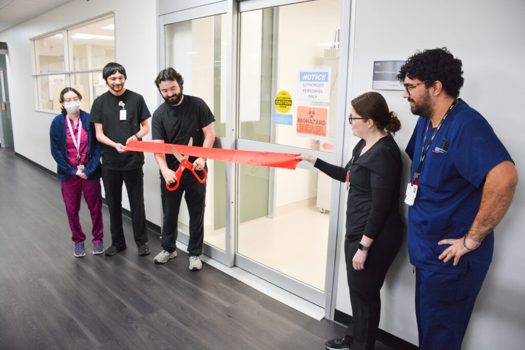 Healthcare staff cutting ribbon at laboratory opening