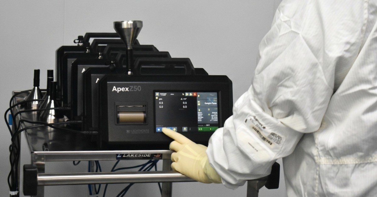 Technician operating Apex Z50 laboratory instrument touchscreen