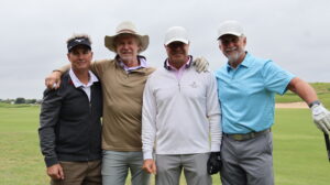 Four men posing together on golf course