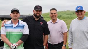 Four men posing on a golf course