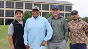 Four men in golf attire outdoors
