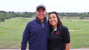 Smiling couple standing on a golf course