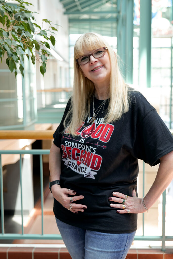 Smiling woman wearing zoo-themed T-shirt indoors