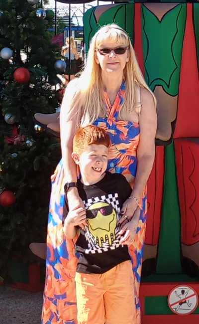 Woman and boy posing by Christmas decorations