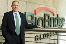 Businessman standing by BioBridge sign indoors