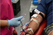 Nurse drawing blood from donor's arm